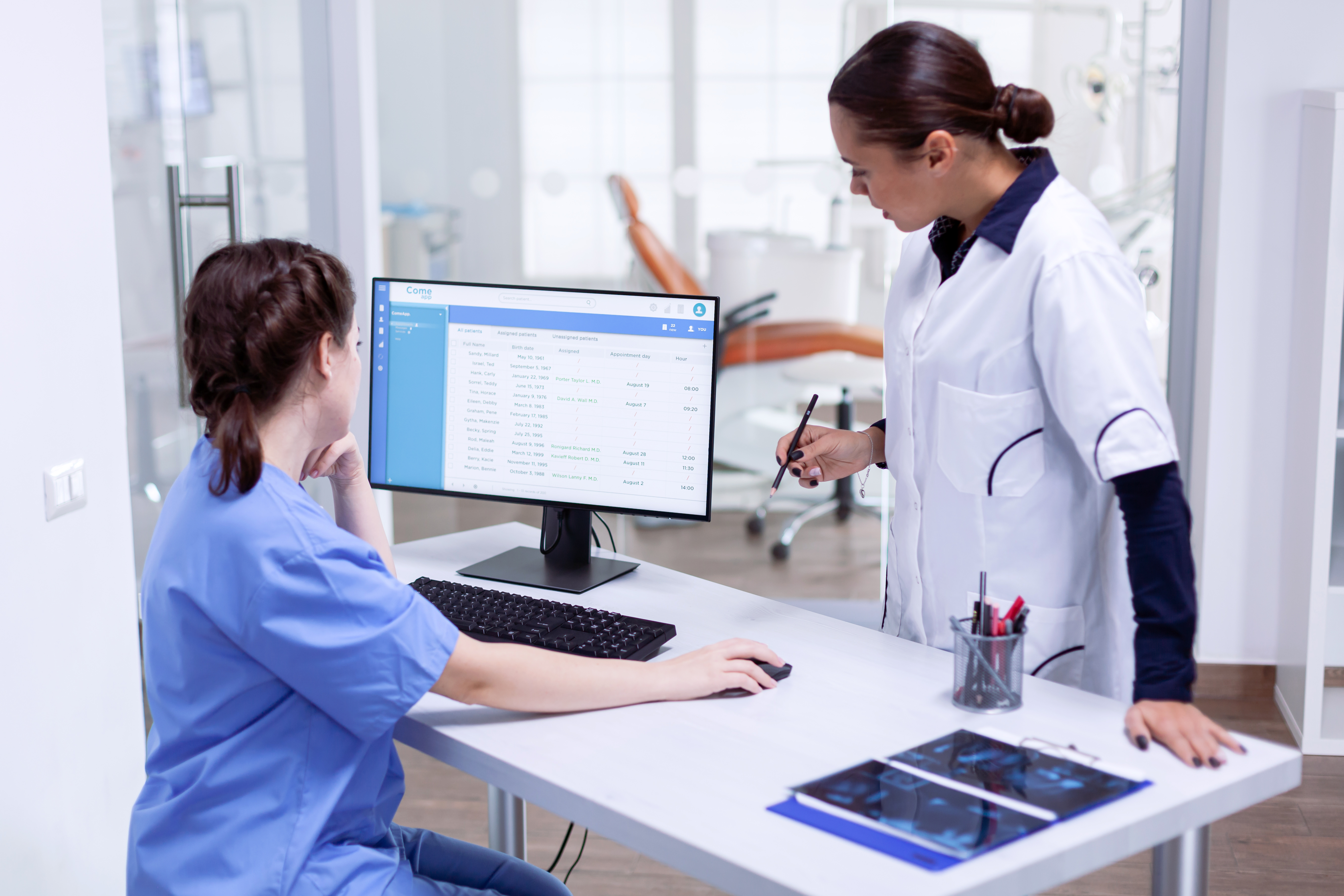 Healthcare professionals reviewing patient billing data on screen